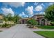 Two-story home with a well-manicured lawn, desert landscaping, and arched entry at 18434 Eastwyck Dr, Tampa, FL 33647