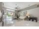 Bright living room boasts white tile flooring, large windows, and a modern ceiling fan for stylish comfort at 18434 Eastwyck Dr, Tampa, FL 33647