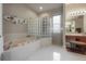 Luxurious main bathroom featuring a soaking tub, glass block accent, and a separate shower for spa-like experience at 18434 Eastwyck Dr, Tampa, FL 33647