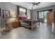 Cozy main bedroom with wood-look floors, four-poster bed, and access to the outdoors at 18434 Eastwyck Dr, Tampa, FL 33647