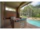 Outdoor kitchen featuring a built-in grill and a view of the pool at 18434 Eastwyck Dr, Tampa, FL 33647
