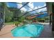 View of the screened-in pool with waterfall, and a hot tub at 18434 Eastwyck Dr, Tampa, FL 33647