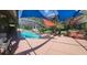 Enclosed pool area with a rock waterfall feature, hot tub, and patio at 18434 Eastwyck Dr, Tampa, FL 33647