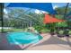 Enjoy this screened pool featuring a charming rock waterfall and sun-protecting sunshades at 18434 Eastwyck Dr, Tampa, FL 33647