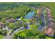 An aerial view showcases a community with a pool, lake, and surrounding lush greenery and homes at 18809 Duquesne Dr, Tampa, FL 33647