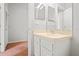 Bathroom vanity featuring cabinet storage, neutral countertop and double mirrors at 18809 Duquesne Dr, Tampa, FL 33647