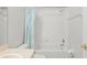 Tiled bathroom with shower-tub combo and blue curtain for privacy at 18809 Duquesne Dr, Tampa, FL 33647