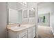 Bathroom with large mirror over vanity, white cabinets, and a view into bedroom at 18809 Duquesne Dr, Tampa, FL 33647