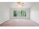 Large, bright bedroom featuring a ceiling fan and a nature view from the window at 18809 Duquesne Dr, Tampa, FL 33647