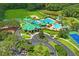 Overhead view of a community club featuring a pool, tennis courts, sand volleyball, and lush green landscaping at 18809 Duquesne Dr, Tampa, FL 33647