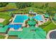 Aerial view of a luxurious community pool with a slide, lanes, splash pad and green surroundings at 18809 Duquesne Dr, Tampa, FL 33647
