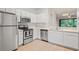 Kitchen view featuring stainless appliances and white cabinetry with backyard view at 18809 Duquesne Dr, Tampa, FL 33647