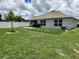 Lawn and paver patio of backyard; house and white fencing in background at 1905 Blue Stream St, Ruskin, FL 33570