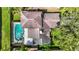 Aerial view of home showcasing roof, screened in pool and spa, and surrounding manicured landscaping at 1906 White Cedar Way, Brandon, FL 33511