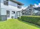 Landscaped backyard with green grass, partial view of screened in pool, and a blue two-story home at 1906 White Cedar Way, Brandon, FL 33511