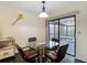 Dining area with a glass table, four chairs, and view of the screened-in patio at 1906 White Cedar Way, Brandon, FL 33511