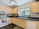 Efficient kitchen showcasing wooden cabinets, a white oven, and a window overlooking the exterior at 1906 White Cedar Way, Brandon, FL 33511