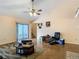 Bright living room featuring a sliding glass door, ceiling fan, and vaulted ceiling at 1906 White Cedar Way, Brandon, FL 33511