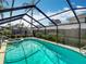 Screened-in pool area with spa features clear blue water and surrounding greenery at 1906 White Cedar Way, Brandon, FL 33511