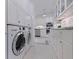 Bright, modern kitchen featuring white cabinets, stainless steel appliances, and adjacent laundry area at 1920 Cherry Ne St, St Petersburg, FL 33704