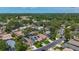 Expansive aerial view of a residential community featuring mature trees, a pool, and tennis courts at 2254 Springrain Dr, Clearwater, FL 33763