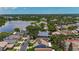 Aerial view of the neighborhood, highlighting a nearby lake, mature trees, and community tennis courts at 2254 Springrain Dr, Clearwater, FL 33763