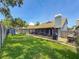 Large, grassy backyard with a screened patio, fenced perimeter, and well-kept lawn at 2254 Springrain Dr, Clearwater, FL 33763
