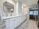 This updated bathroom features double sinks, modern cabinets, a big mirror, and tile floors at 2254 Springrain Dr, Clearwater, FL 33763