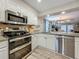 Open-concept kitchen with stainless steel appliances and view into dining and living spaces at 2254 Springrain Dr, Clearwater, FL 33763