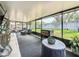 Large enclosed patio with outdoor seating, grilling area, and views of the fenced backyard at 2254 Springrain Dr, Clearwater, FL 33763