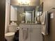 Bathroom vanity with modern fixtures, granite countertop, and decorative flower accents at 2500 Winding Creek Blvd # B105, Clearwater, FL 33761