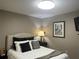 Comfortable bedroom with a decorative upholstered headboard, plush pillows, and pelican artwork at 2500 Winding Creek Blvd # B105, Clearwater, FL 33761