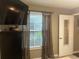Bedroom displaying a wall-mounted television, sheer window curtains, and neutral wall paint at 2500 Winding Creek Blvd # B105, Clearwater, FL 33761
