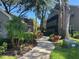 Lush landscaped walkway leading to charming multi-story condo building in a serene community at 2500 Winding Creek Blvd # B105, Clearwater, FL 33761