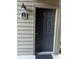Welcoming entryway featuring a dark front door with a unit number, complemented by siding and outdoor lighting at 2500 Winding Creek Blvd # B105, Clearwater, FL 33761