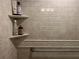 Shower featuring tiled walls, recessed shelving, and a convenient grab bar for enhanced safety and accessibility at 2500 Winding Creek Blvd # B105, Clearwater, FL 33761