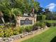 Community sign for The Fountains at Countryside, featuring lush landscaping and an American flag at 2500 Winding Creek Blvd # B105, Clearwater, FL 33761