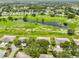 Golf course community featuring manicured green lawns and community pond from an aerial view at 2609 Lancaster Dr, Sun City Center, FL 33573