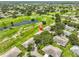 Aerial view of neighborhood featuring lush green lawns, mature trees, ponds and golf course at 2609 Lancaster Dr, Sun City Center, FL 33573
