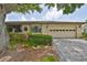 Charming single-story home with a well-manicured lawn, tidy shrubbery, and a driveway leading to an attached two-car garage at 2609 Lancaster Dr, Sun City Center, FL 33573