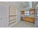 Eat-in kitchen featuring a stainless steel dishwasher, tiled floors, ample cabinet space, and a ceiling fan at 2609 Lancaster Dr, Sun City Center, FL 33573