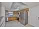 Bright kitchen with stainless steel appliances, light wood cabinets, ample counter space, and a ceiling fan at 2609 Lancaster Dr, Sun City Center, FL 33573