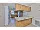 Kitchen featuring wooden cabinets, stainless steel appliances, tile flooring, and a breakfast bar at 2609 Lancaster Dr, Sun City Center, FL 33573