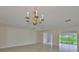 Bright living area with chandelier, tile floors, and sliding glass doors, enhancing the open and airy feel at 2609 Lancaster Dr, Sun City Center, FL 33573