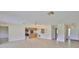 Open-concept living space featuring tile flooring, a ceiling fan, and a pass-through to the kitchen area at 2609 Lancaster Dr, Sun City Center, FL 33573