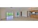 Open living space with tile flooring, seamless access to outdoor screened lanai, and an adjoining kitchen at 2609 Lancaster Dr, Sun City Center, FL 33573
