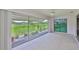 Light-filled sunroom with sliding glass doors offering views of the lush green lawn at 2609 Lancaster Dr, Sun City Center, FL 33573