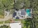 Aerial view of a home featuring solar panels, a refreshing pool, and lush green landscaping at 2718 Boca Ciega N Dr, St Petersburg, FL 33710