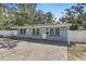 Inviting single-story home with a light gray exterior, updated windows and a well-manicured front yard at 2718 Boca Ciega N Dr, St Petersburg, FL 33710