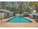Inviting in-ground pool is surrounded by a brick patio and lush greenery at 2718 Boca Ciega N Dr, St Petersburg, FL 33710